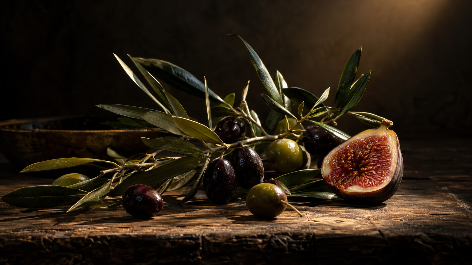 Olive branch and halved fig in dramatic light, illustrating the longevity claims section
